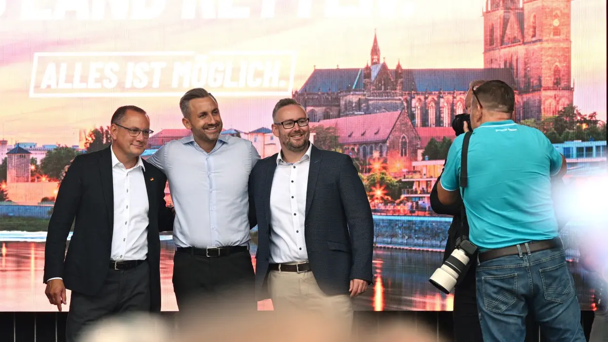 Wahlkampf Sachsen-Anhalt - AfD: 04.09.2026, Sachsen-Anhalt, Magdeburg: Tino Chrupalla (l-r), AfD-Bundes- und Fraktionsvorsitzender, Ulrich Siegmund, Spitzenkandidat der AfD für die Landtagswahl in Sachsen-Anhalt, und Sebastian Münzenmaier, stellvertretender Vorsitzender der AfD-Bundestagsfraktion, posieren bei einem Familienfest der Partei auf der Bühne für ein Foto. Foto: Michael Brandt/dpa +++ dpa-Bildfunk +++