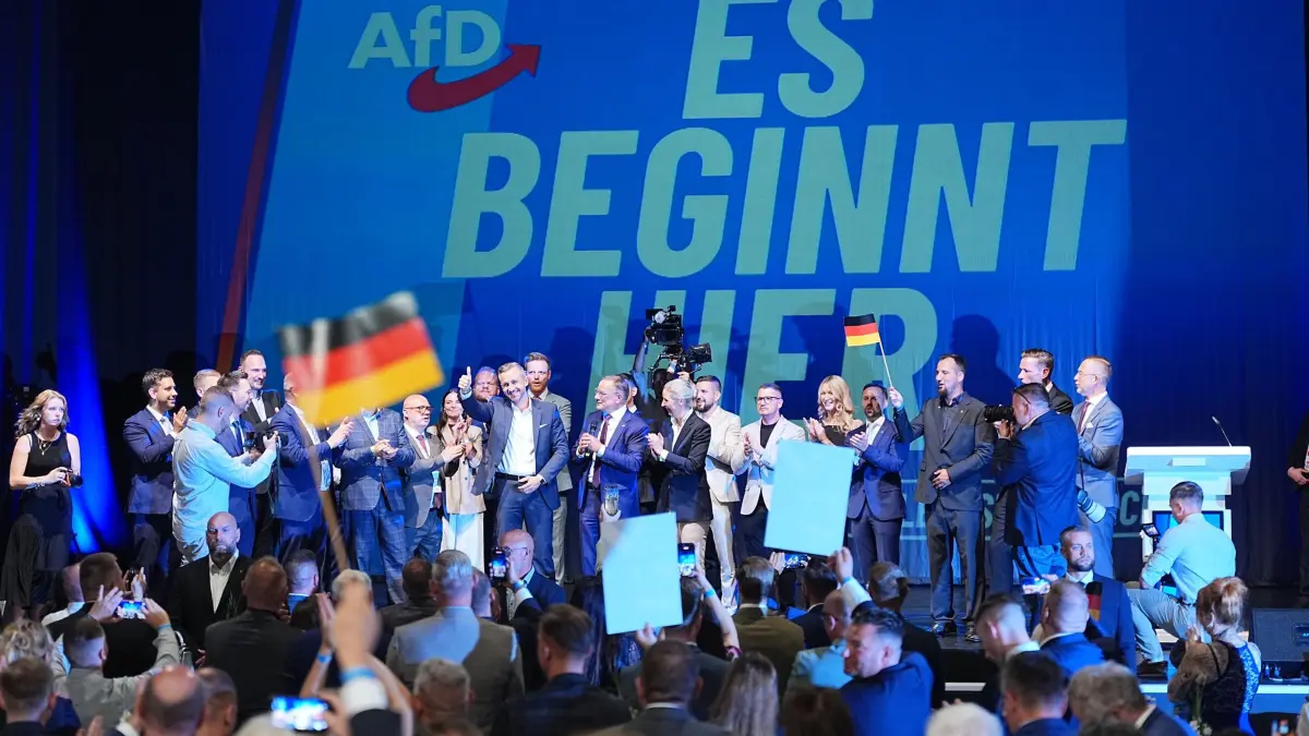 Landtagswahl in Sachsen-Anhalt - Wahlparty AfD: 06.09.2026, Sachsen-Anhalt, Magdeburg: Ulrich Siegmund (Mitte l, AfD), Spitzenkandidat und Co-Vorsitzender der AfD-Landtagsfraktion Sachsen-Anhalt, steht mit Funktionären der AfD bei der Wahlparty der AfD im Alten Theater vor dem Schriftzug "Es beginnt hier" auf der Bühne. Am Sonntag (06.09.2026) wurde in Sachsen-Anhalt ein neuer Landtag gewählt. (zu dpa: «Politologe: AfD ähnelt Volkspartei») Foto: Michael Kappeler/dpa +++ dpa-Bildfunk +++