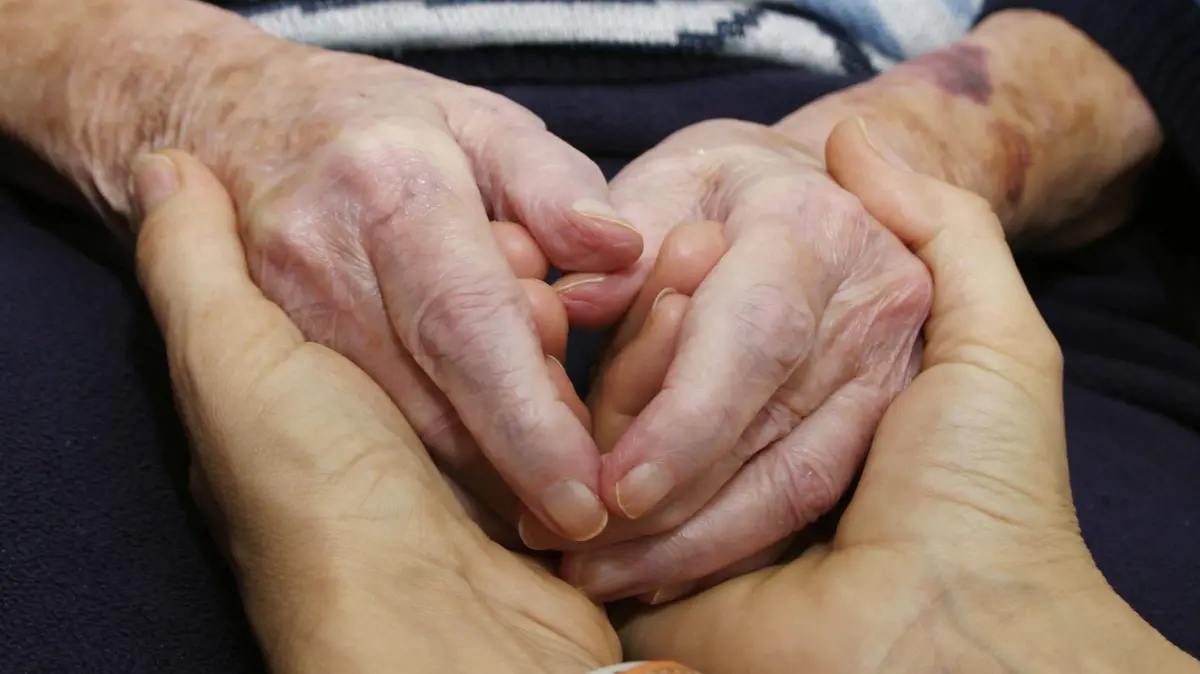 Heimbewohner in einem Pflegeheim GER,20250607, Pflegerin haelt die Haende einer Heimbewohnerin *** Resident in a nursing home GER,20250607, nurse holding the hands of a resident