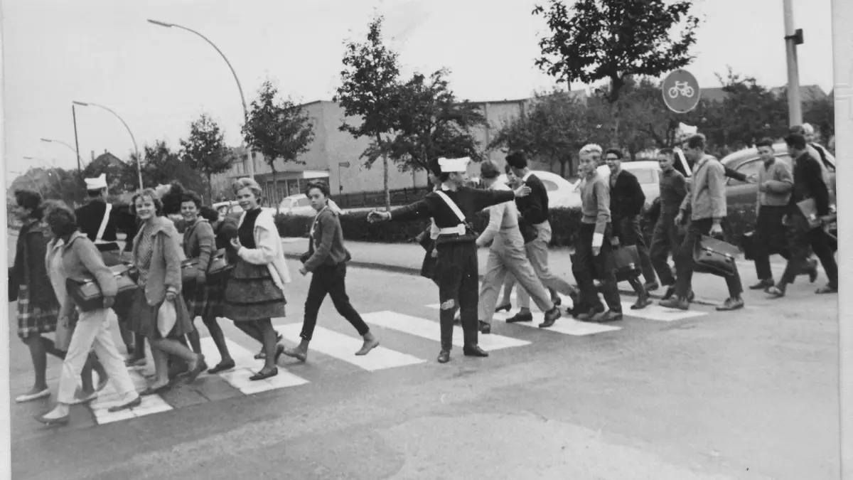 Das Bild zeigt einen Fußgängerüberweg vor dem Rathaus in Kornwestheim in den sechziger Jahren, der von Schülerlotsen gesichert wurde.