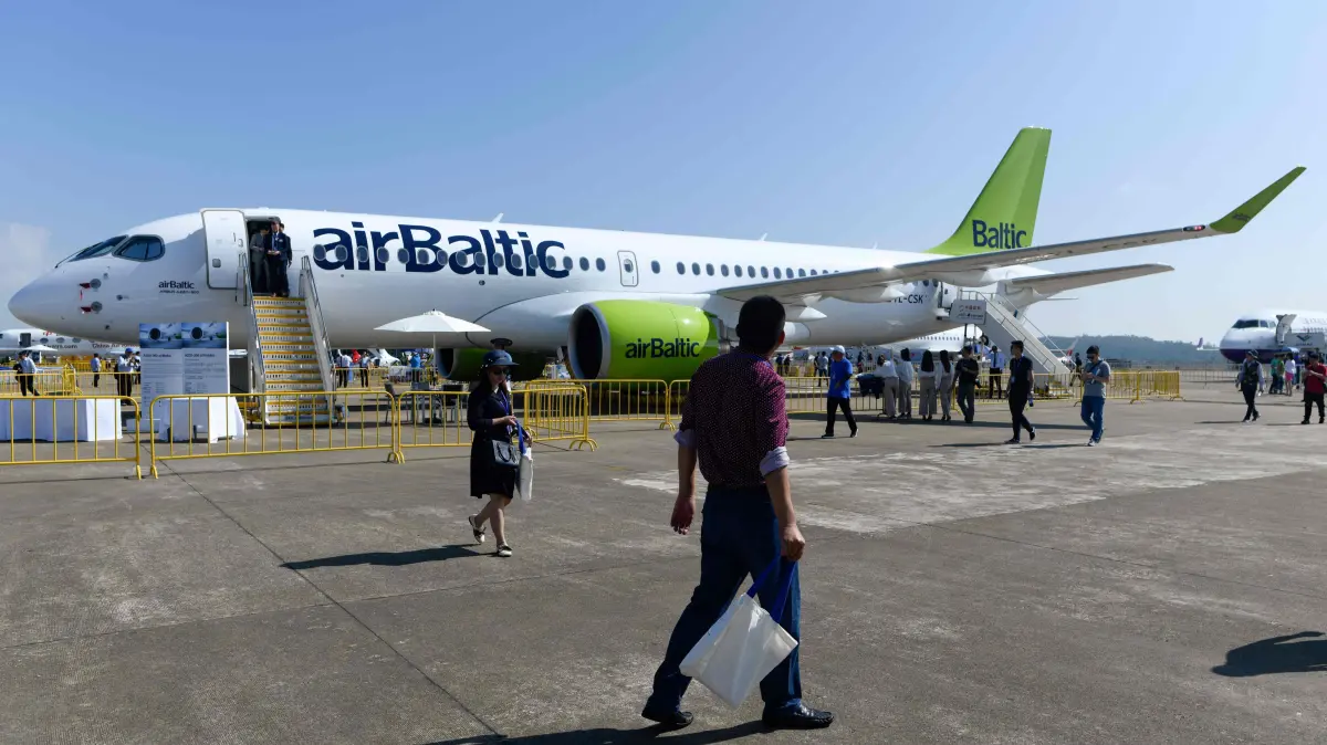 FILES-CHINA-LATVIA-TRANSPORT-AVIATION-BANKRUPTCY-AIRBALTIC: (FILES) This photograph taken at Airshow China 2018 in Zhuhai in southern China's Guangdong province on November 7, 2018 shows visitors looking at an Airbus A220-300 air Baltic passenger plane. Latvia's AirBaltic said on September 14, 2026 that it had filed for protection under Chapter 11 of the US Bankruptcy Code, as it tries to reduce its debt amid increased fuel prices brought on by the Iran war. (Photo by WANG Zhao / AFP)