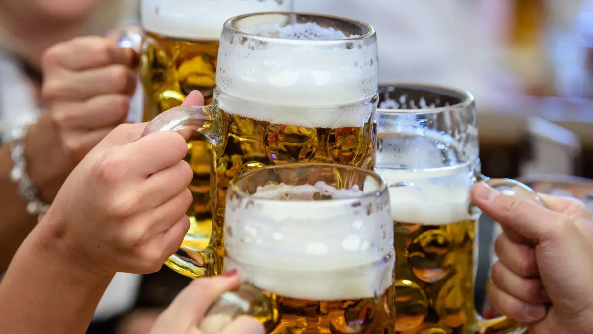 Bierpreisinflation auf der Wiesn: ARCHIV - 21.09.2019, Bayern, München: Besucher stoßen auf dem Münchner Oktoberfest mit Bier an. (zu dpa: «Inflation auf der Wiesn: Maß Bier fünfmal so teuer wie 1985») Foto: Matthias Balk/dpa +++ dpa-Bildfunk +++