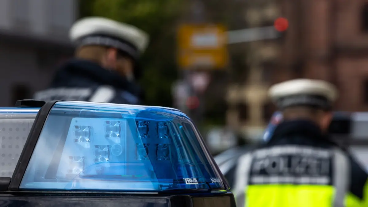 Symbolbild - Polizei: ARCHIV - 05.05.2021, Baden-Württemberg, Freiburg: Zwei Polizeibeamte stehen zwischen zwei Einsatzfahrzeugen der Polizei. (zu dpa: «Betrunkener feuert Schüsse aus Schreckschusswaffe ab») Foto: Philipp von Ditfurth/dpa +++ dpa-Bildfunk +++