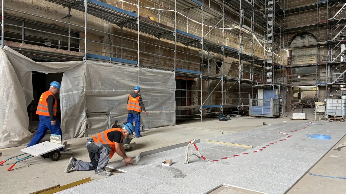 Hauptbahnhof Stuttgart, Bonatzbau, Große Schalterhalle. Arbeiter verlegen einen neuen Bodenbelag