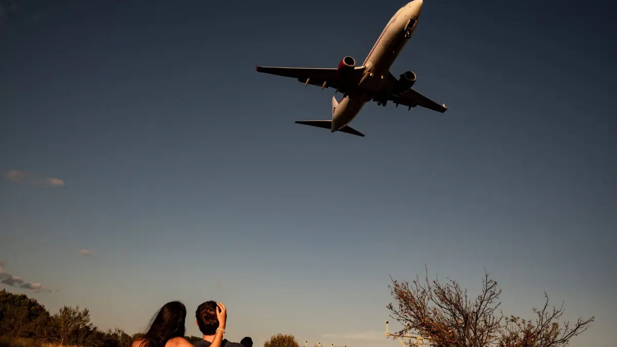 Flughafen Barcelona: 18.09.2026, Spanien, El Prat de Llobregat: Ein Paar beobachtet von einem Aussichtspunkt aus, wie ein Passagierflugzeug zur Landung auf dem Flughafen Barcelona-El Prat ansetzt. Foto: Jordi Boixareu/ZUMA Press Wire/dpa +++ dpa-Bildfunk +++