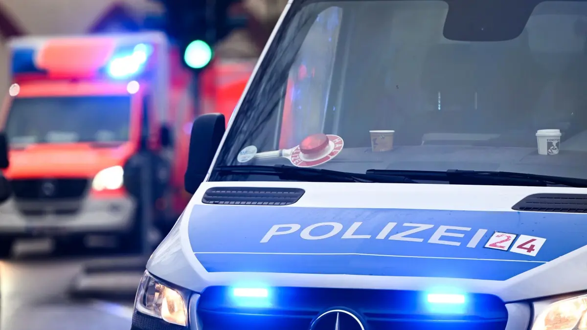 Polizei und Krankenwagen: Ein Polizeiauto und ein Rettungswagen mit Blaulicht. (zu dpa: «Tödlicher Unfall: Auto stürzt von Brücke auf S-Bahn-Gleise»)