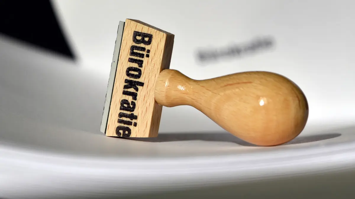 Bürokratie: ARCHIV - 12.02.2015, Brandenburg, Potsdam: Ein Stempel mit der Aufschrift «Bürokratie» liegt auf Papieren. (zu dpa: «Standortprobleme: Bürokratie mit großem Abstand vorne») Foto: Ralf Hirschberger/dpa-Zentralbild/dpa +++ dpa-Bildfunk +++