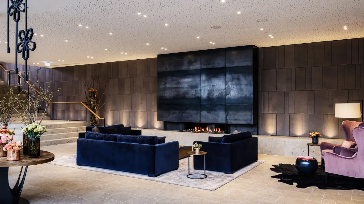 In der Lobby wird der Kamin zum Treffpunkt für ruhige Momente und anregende Gespräche.