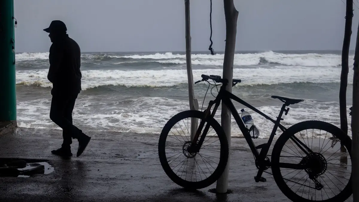 MEXICO-CLIMATE-WEATHER-HURRICANE-POLO: A man walks along the shore as strong waves churn the waters off Playa Azul, in the municipality of Lazaro Cardenas, Michoacan, Mexico, on September 23, 2026. Hurricane Polo strengthened to the highest category on September 22 in the Mexican Pacific, with no forecast of making landfall but with heavy rainfall expected. Polo intensified from Category 1 to Category 5 on the Saffir-Simpson scale in less than 24 hours. (Photo by Enrique Castro / AFP)
