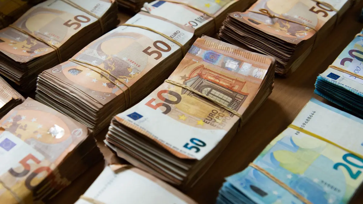 Beschlagnahmte Euro-Banknoten: ARCHIV - 03.05.2019, Hessen, Wiesbaden: Euro-Banknoten liegen während einer Pressekonferenz im Bundeskriminalamt gebündelt auf einem Tisch. Die Euro-Banknoten wurden bei Hausdurchsuchungen beschlagnahmt. Ermittler haben zuvor einen kriminellen Online-Marktplatz für Drogen und andere illegale Waren ausgehoben. (zu dpa: «EU-weite Abschöpfung von ergaunertem Vermögen soll leichter werden») Foto: Silas Stein/dpa +++ dpa-Bildfunk +++