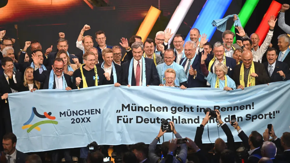 DOSB wählt deutschen Olympia-Bewerber: Sportpolitik: Markus Söder (CSU, M), Ministerpräsident von Bayern, und Dominik Krause (Bündnis 90/Die Grünen), Oberbürgermeister von München, und weitere Mitglieder der Münchner Delegation jubeln auf der Bühne bei der außerordentlichen DOSB-Mitgliederversammlung zur Wahl des deutschen Olympia-Bewerbers für 2036, 2040 oder 2044. München ist der deutsche Kandidat für Olympia und Paralympics für 2036, 2040 oder 2044. (zu dpa: «Jetzt in die Achterbahn: Wie München Olympia holen will»)