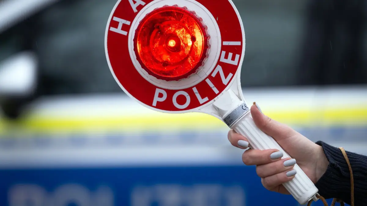 Drogen, Waffen und Geld bei Verkehrskontrolle gefunden: ARCHIV - 22.03.2024, Brandenburg, Trebbin: Eine Polizistin hält während einer Verkehrskontrolle eine Polizeikelle mit der Aufschrift „Halt Polizei“. (Symbolbild) (zu dpa: «Drogen, Waffen, Geld: Kontrolle endet in Strafverfahren») Foto: Soeren Stache/dpa +++ dpa-Bildfunk +++
