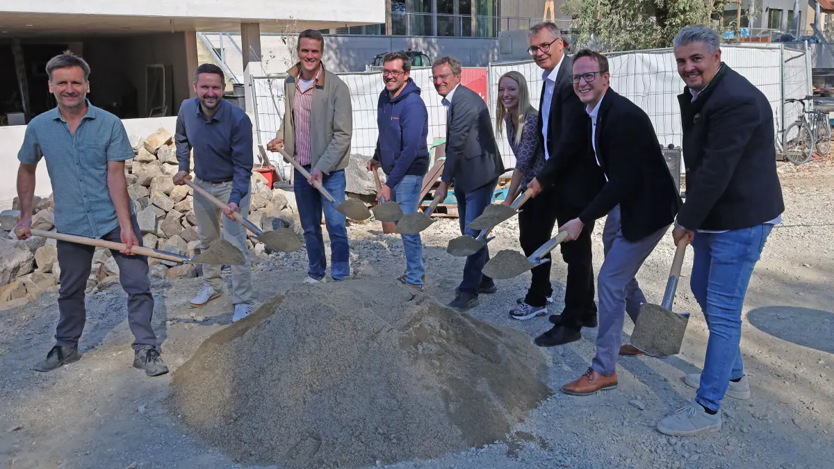 Mit dem Spatenstich am 28. September 2026 beginnt die Neugestaltung der öffentlichen Freianlagen an der Neckarstraße am Belsers Hotel. Das Projekt, dessen Elemente auf Anregungen aus einem Bürgerbeteiligungsprozess basieren, will Erholung, Kunst und Gastronomie verbinden. Das Foto zeigt v.l.n.r.: Landschaftsarchitekt Thomas Frank, Tiefbauamtsleiter Matthias Eisenschmit, Max-Martin Gegner (Gartenbaufirma Seidenspinner), Kai Wogurek (technischer Geschäftsleiter, KuKuK GmbH), Rainer Gessler (stv. Verbandsvorsitzender der Regionalversammlung), Regionalrätin Pia Schwarz, Regionaldirektor Dr. Alexander Lahl, Oberbürgermeister Dr. Johannes Fridrich und Gastronom Christer Belser.