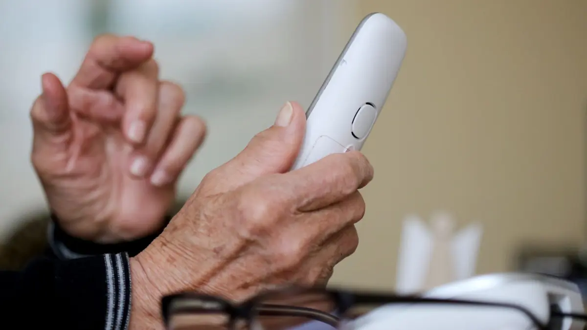 Telefonbetrug in Erfurt: ARCHIV - 10.03.2021, Nordrhein-Westfalen, Essen: Ein Senior hält einen Telefonhörer in der Hand. (zu dpa: «Falscher Arzt bringt mit Schockanruf Seniorin um viel Geld») Foto: Roland Weihrauch/dpa +++ dpa-Bildfunk +++