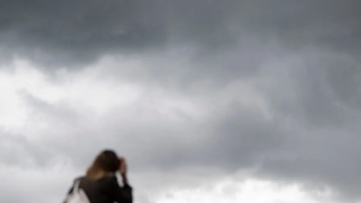 Regen: ARCHIV - 11.06.2026, Baden-Württemberg, Stuttgart: Eine Passantin geht in der Innenstadt vor grauen Wolken. (zu dpa: «Wo Wolken und Gewitter das Herbstwochenende trüben können») Foto: Marijan Murat/dpa +++ dpa-Bildfunk +++