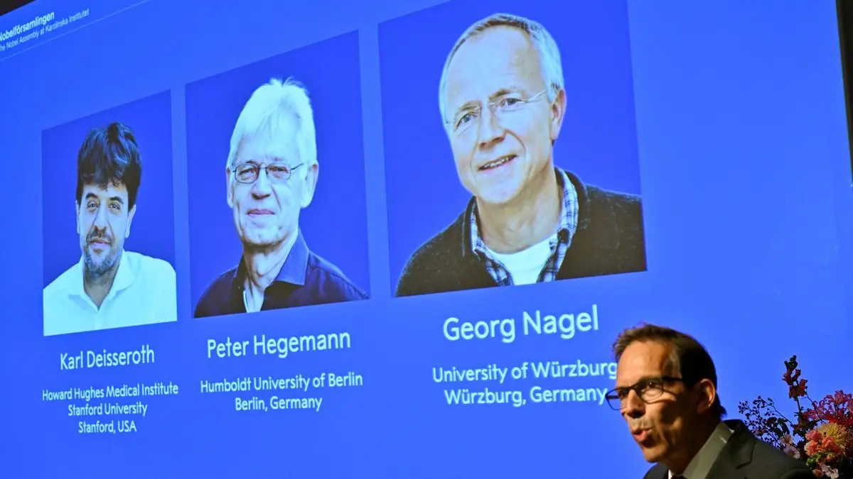 Karl Deisseroth, Peter Hegemann und Georg Nagel sind auf dem Bildschirm zu sehen, als ihnen der Nobelpreis für Physiologie oder Medizin 2026 verliehen wird. Dies wird im Rahmen einer Pressekonferenz im Nobel-Forum am Karolinska-Institut in Stockholm, Schweden, bekannt gegeben.