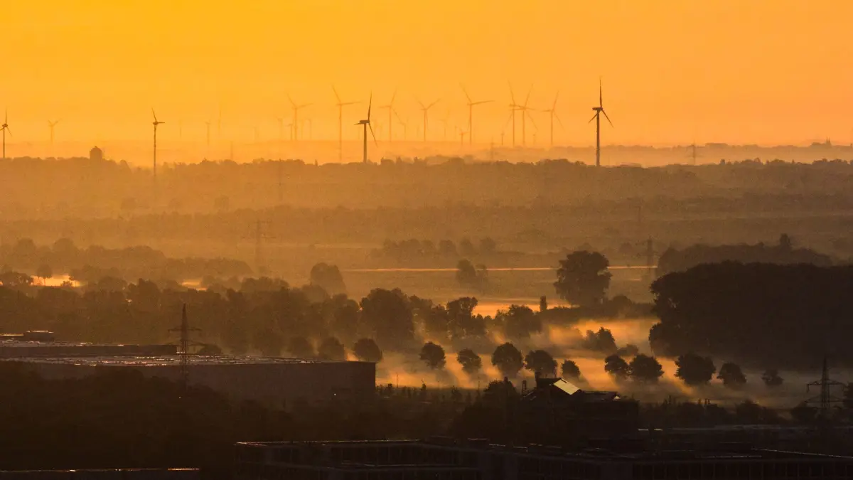 Herbst in Niedersachsen: Windräder und Nebel zeichnen sich im Licht der aufgehenden Sonne in der Region Hannover ab. (zu dpa: «Bilder des Tages»)