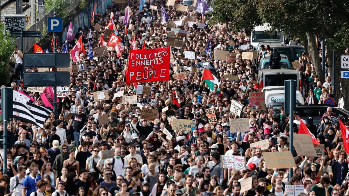 Schulproteste in Frankreich: Studierende mit einem großen roten Transparent mit der Aufschrift „Polizisten, Feinde des Volkes“ marschieren in Rennes im Westen Frankreichs bei einer Demonstration gegen unterfinanzierte Schulen. (zu dpa: «Macron ruft zu Krisensitzung – Schulproteste weiten sich aus»)