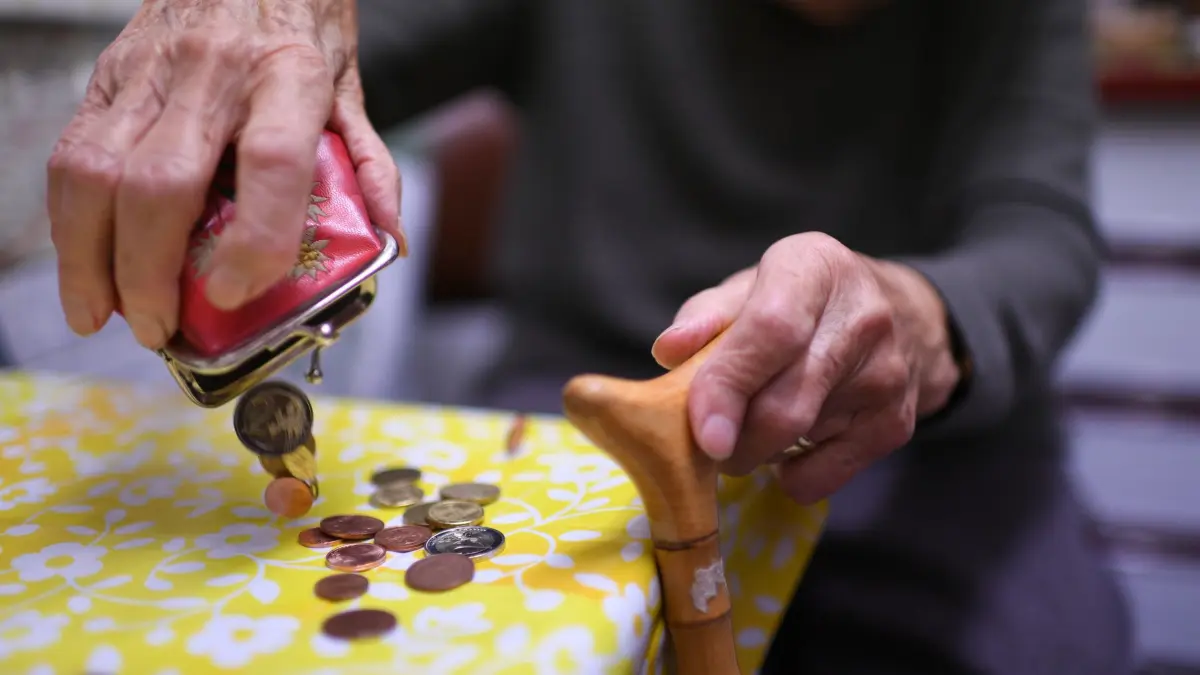 Grundsicherung im Alter: Eine Rentnerin schüttet den Inhalt ihres Geldbeutels auf den Küchentisch. (zu dpa: «Sorgen um Geld – Frauen fühlen sich finanziell unsicherer»)