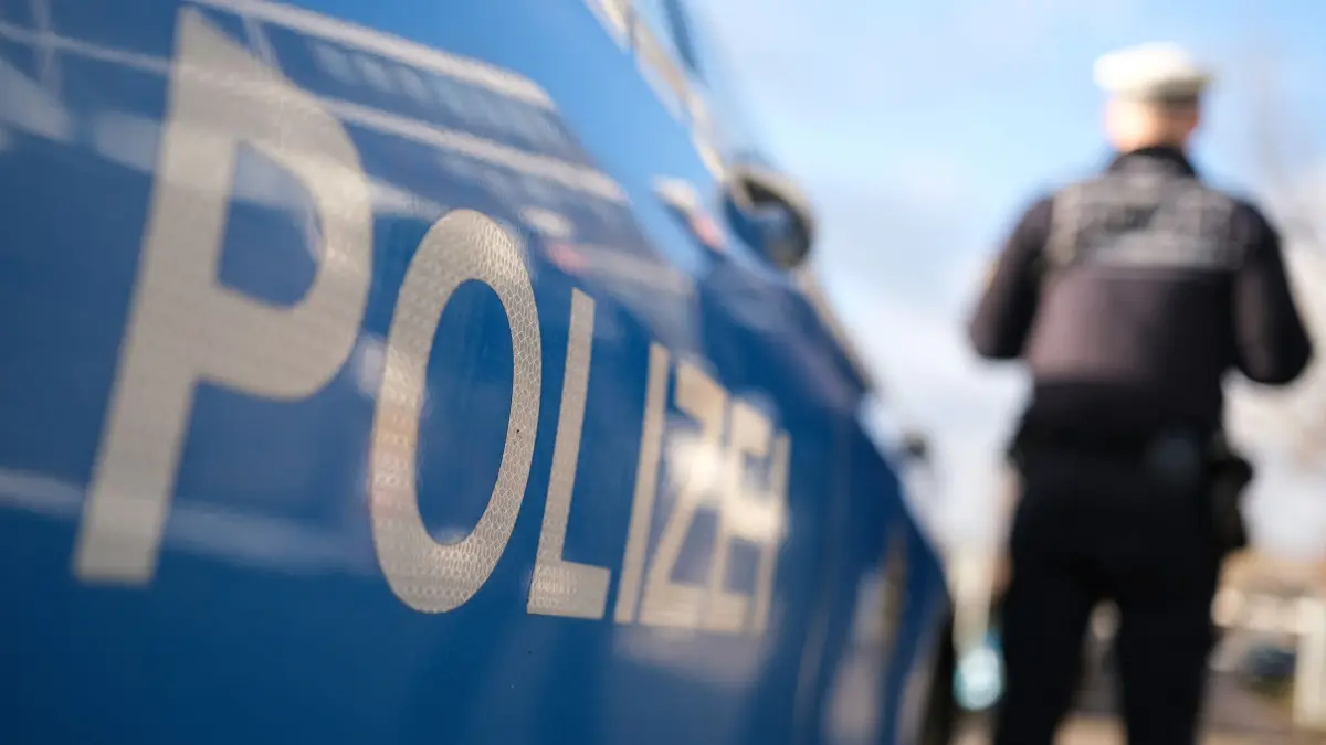 Polizei: ARCHIV - 03.12.2024, Baden-Württemberg, Stuttgart: Ein Polizist steht vor einem Dienstfahrzeug (gestellte Szene). (zu dpa: «Mann filmt Frau durchs Schlafzimmerfenster») Foto: Bernd Weißbrod/dpa +++ dpa-Bildfunk +++