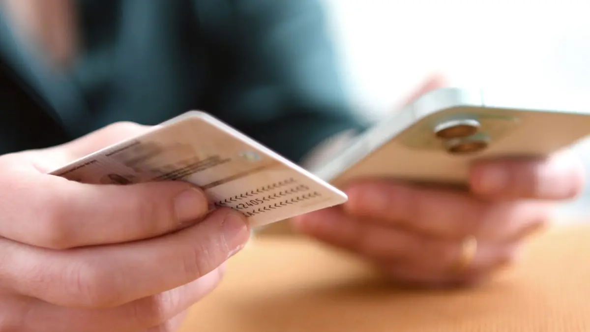 Eine Frau hält Personalausweis und Smartphone in den Händen: ILLUSTRATION - Online-Ausweis deaktiviert oder PIN vergessen? Ein kostenloser Rücksetzbrief lässt sich jetzt online bestellen. Foto: Zacharie Scheurer/dpa-mag - Honorarfrei nur für Bezieher des Dienstes dpa-Magazin +++ dpa-Magazin +++