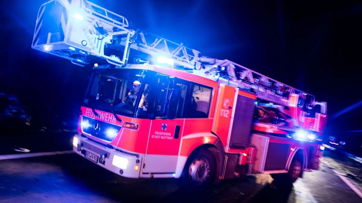 Feuerwehr in NRW: ARCHIV - 21.01.2018, Nordrhein-Westfalen, Bottrop: ILLUSTRATION - Ein Drehleiterwagen der Feuerwehr fährt mit Blaulicht an einer Unfallstelle vorbei. (zu dpa: «Drei Tote bei Brand in Bochum») Foto: Marcel Kusch/dpa +++ dpa-Bildfunk +++