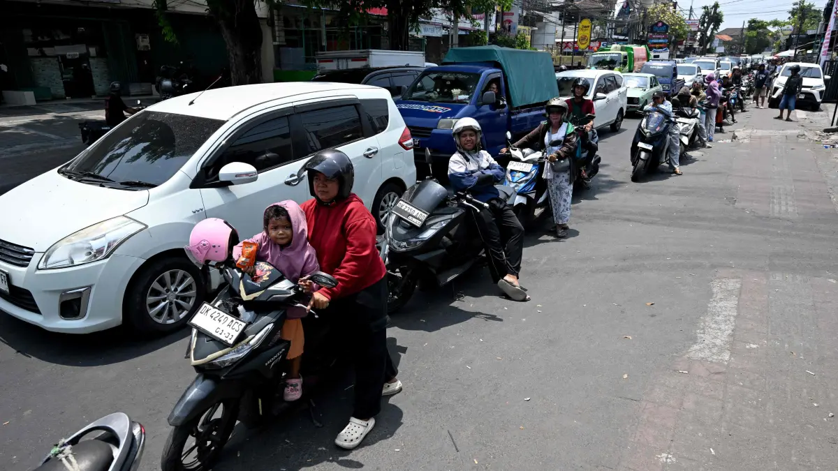INDONESIA-ENERGY-OIL: Motorcyclists queue to refuel at a gas station in Denpasar amid a fuel supply shortage on Indonesia's resort island of Bali on October 14, 2026. (Photo by SONNY TUMBELAKA / AFP)