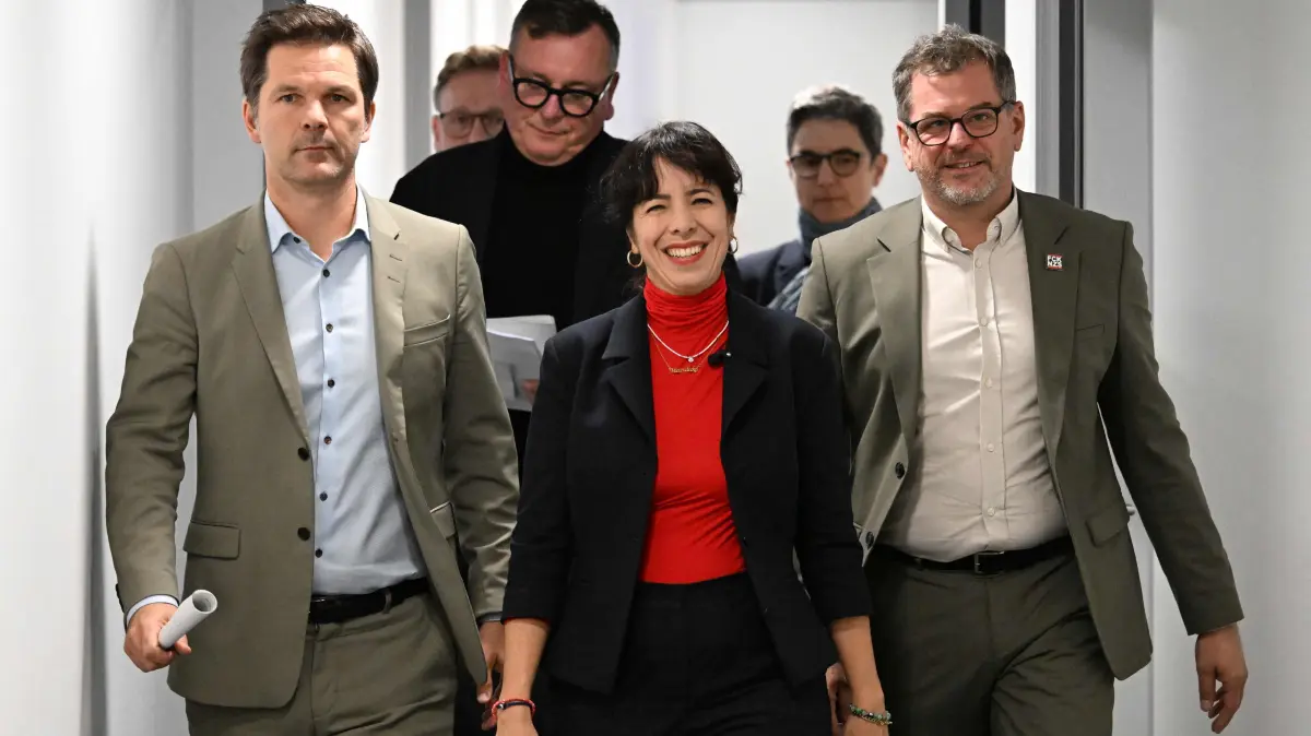 GERMANY-POLITICS-VOTE-PARTIES: (L-R) Steffen Krach, co-leader of Berlin's Social Democratic Party (SPD), Elif Eralp, parliamentary group leader of the left-wing Die Linke party in Berlin's House of Representatives and Werner Graf of the Greens, arrive to address a press conference on October 17, 2026 after agreeing to start exploratory talks to form a government following Berlin elections. (Photo by RALF HIRSCHBERGER / AFP)