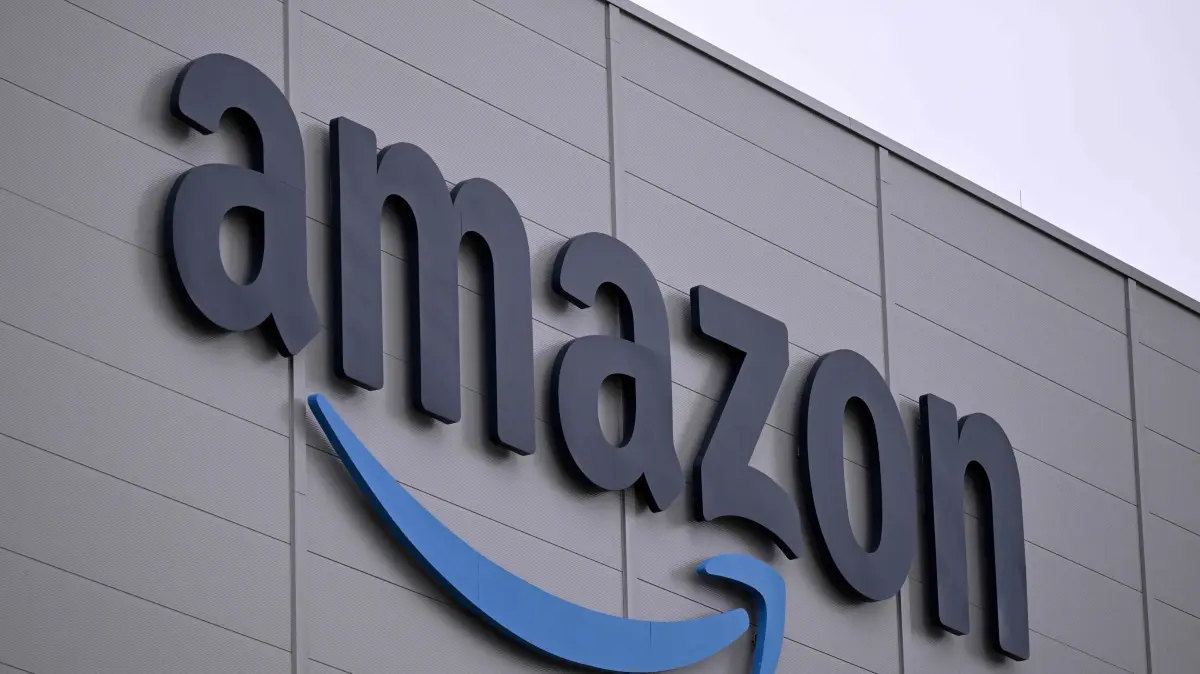 FILES-GERMANY-RETAIL-TECHNOLOGY-AMAZON-INVESTMENTS: (FILES) The logo of US online retail giant Amazon is seen on the facade of a redistribution centre in Horn-Bad Meinberg, western Germany, on December 9, 2024. US tech giant Amazon on October 20, 2026 announced plans to invest over 16 billion euros ($18 billion) in Germany next year, including on data centres and other infrastructure underpinning the artificial intelligence revolution. (Photo by Ina FASSBENDER / AFP)