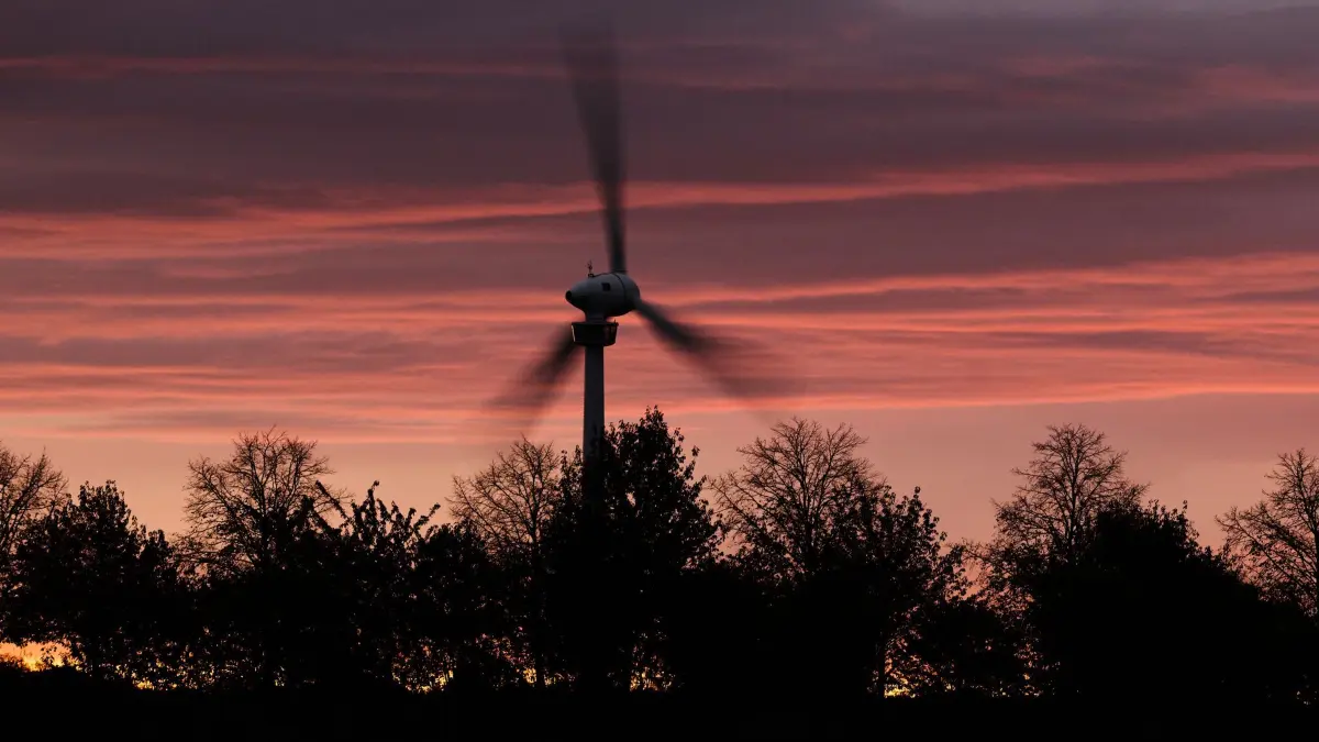 Sturmtief Luise - Hannover: 23.10.2026, Niedersachsen, Hannover: Ein Windrad dreht vor sich vor der vom Sonnenaufgang verfärbten Wolkenkulisse. Das Sturmtief Luise zieht über Teile Deutschlands hinweg. (Aufnahme mit Langzeitbelichtung) (zu dpa: «Wechselhaftes Herbstwetter mit Sturmböen») Foto: Julian Stratenschulte/dpa +++ dpa-Bildfunk +++