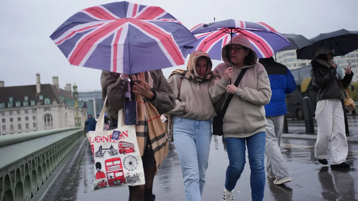Herbstwetter in London: 24.10.2026, Großbritannien, London: Menschen im Regen auf der Westminster Bridge in London. Für Samstag gilt eine Wetterwarnung der Stufe „Gelb“ für ganz Schottland, den Norden Englands bis hinunter nach Carlisle sowie den Nordosten Nordirlands. Der Sturm „Boelo“, der zweite benannte Sturm der Saison, folgt auf den Sturm „Austen“, der am Freitag den Südwesten heimgesucht hat. Foto: Yui Mok/PA Wire/dpa +++ dpa-Bildfunk +++