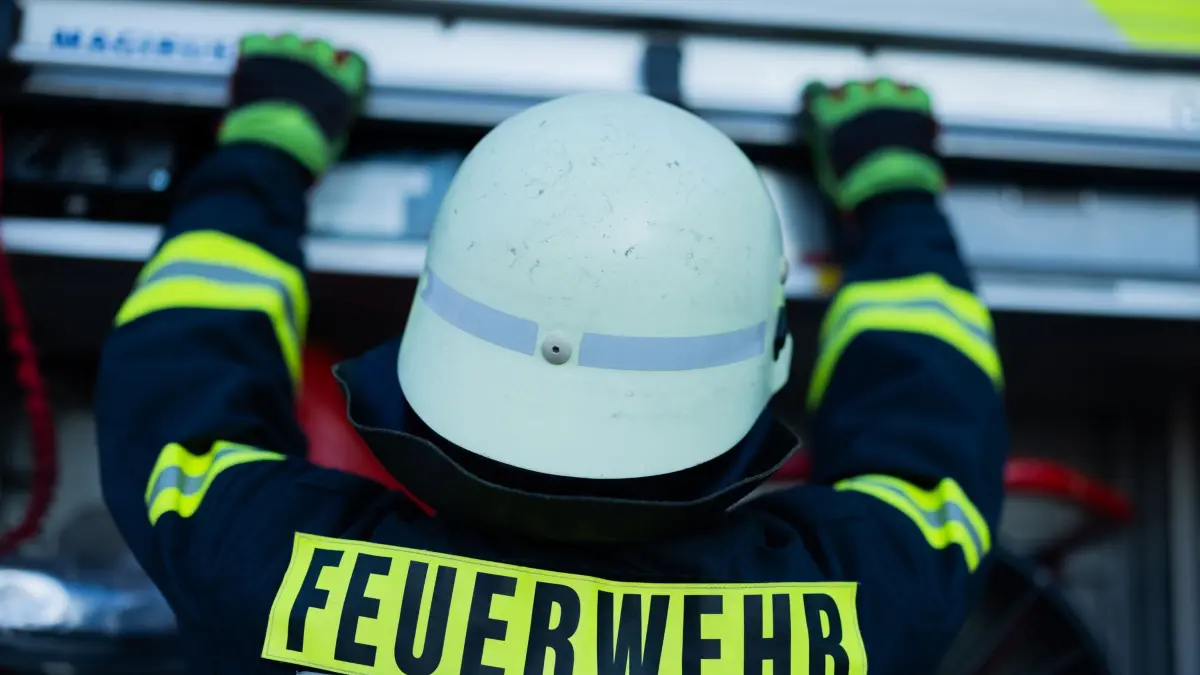 Feuerwehr - Symbolbild: ARCHIV - 11.01.2024, Nordrhein-Westfalen, Leverkusen: Ein Feuerwehrmann holt Equipment aus einem Einsatzfahrzeug an der Feuerwache der Feuerwehr. (zu dpa: «Brand in Mehrfamilienhaus verursacht hohen Schaden») Foto: Rolf Vennenbernd/dpa +++ dpa-Bildfunk +++