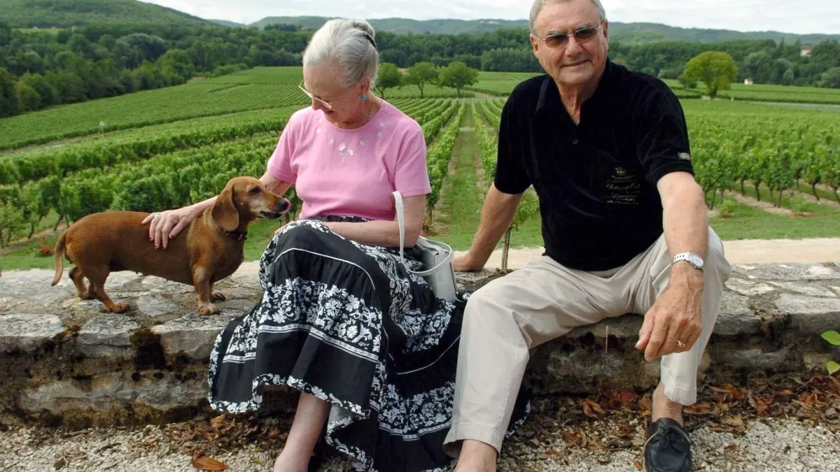 Die dänische Königin Margrethe II. und ihr Ehemann, Prinz Henrik, 2004 mit einem ihrer Dackel im Garten ihres Schlosses Caix bei Cahors in Südfrankreich.