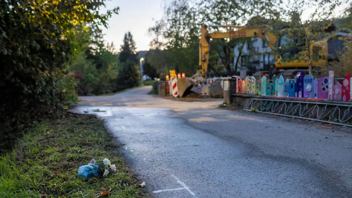 Frau und Kleinkind sterben bei Unfall mit Lastwagen: Markierungen und ein kleines Blumengesteck sind nahe einer Unfallstelle auf dem nassen Asphalt zu sehen. Eine Frau und ein Kleinkind starben heute bei einem Unfall mit einem Lastwagen. (zu dpa: «Fußgängerin und Enkelkind sterben bei Unfall mit Lkw»)